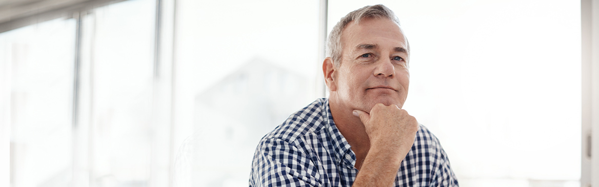 Man resting head on hand smiling Man resting head on hand smiling
